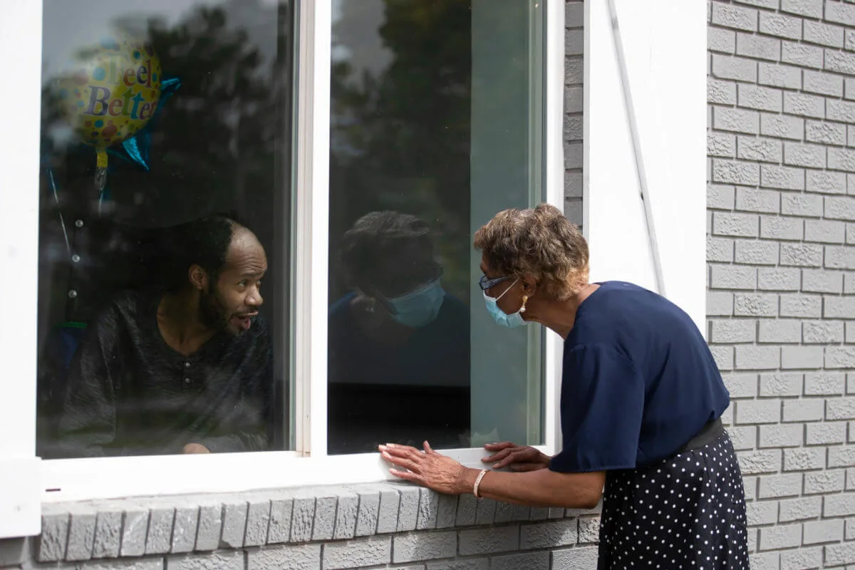 Window visits have become a common scene as relatives try to visit nursing home residents during the Pandemic. (AP Photo/John Bazemore)