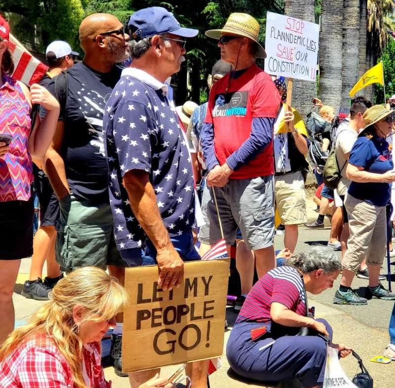 man at pro trump rally holding let my people go sign