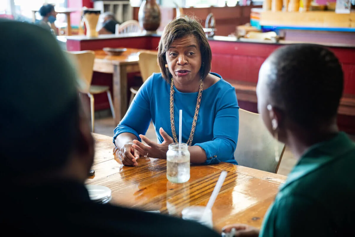Cheri Beasley sits at a table in a restaurant with potential supporters in Durham, NC.