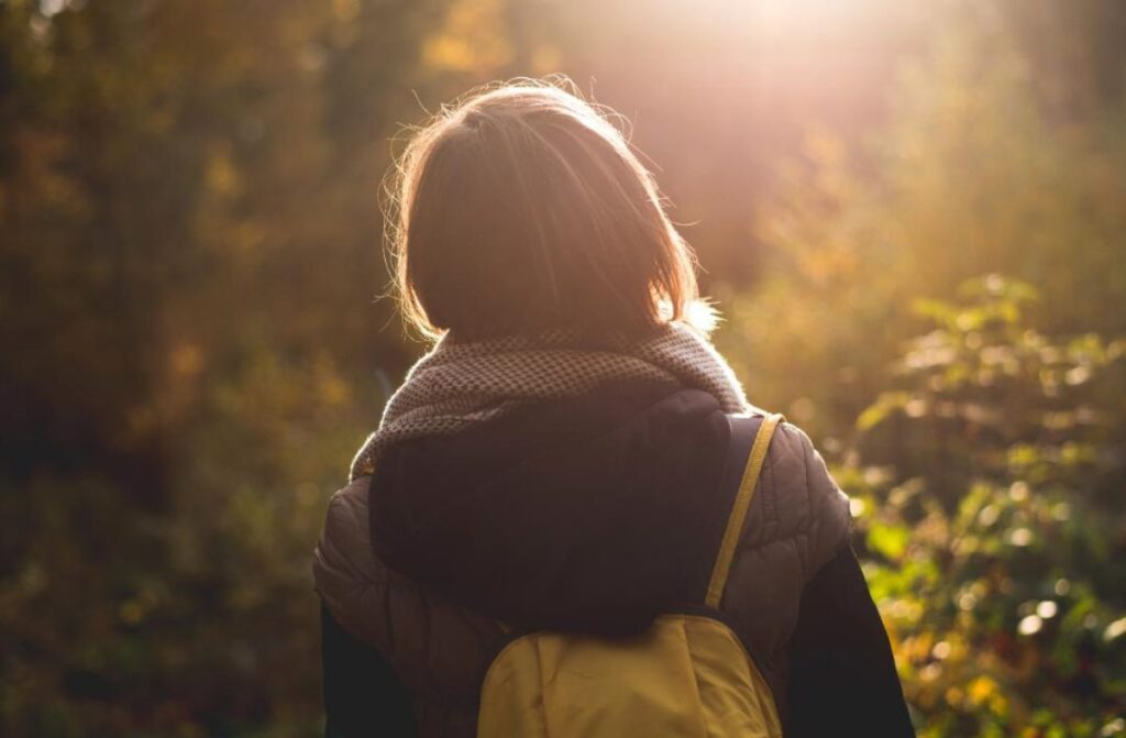 Young woman walking through the woods.