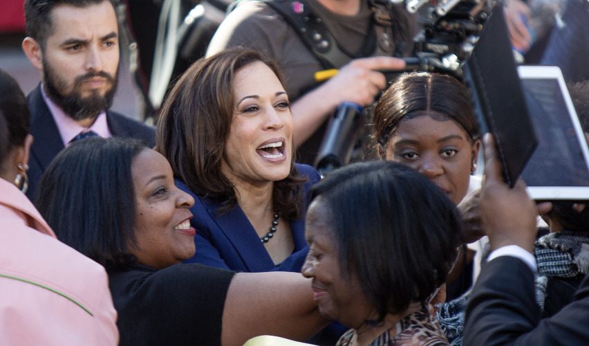 Vice President Kamala Harris flanked by women in a 2019 rally.