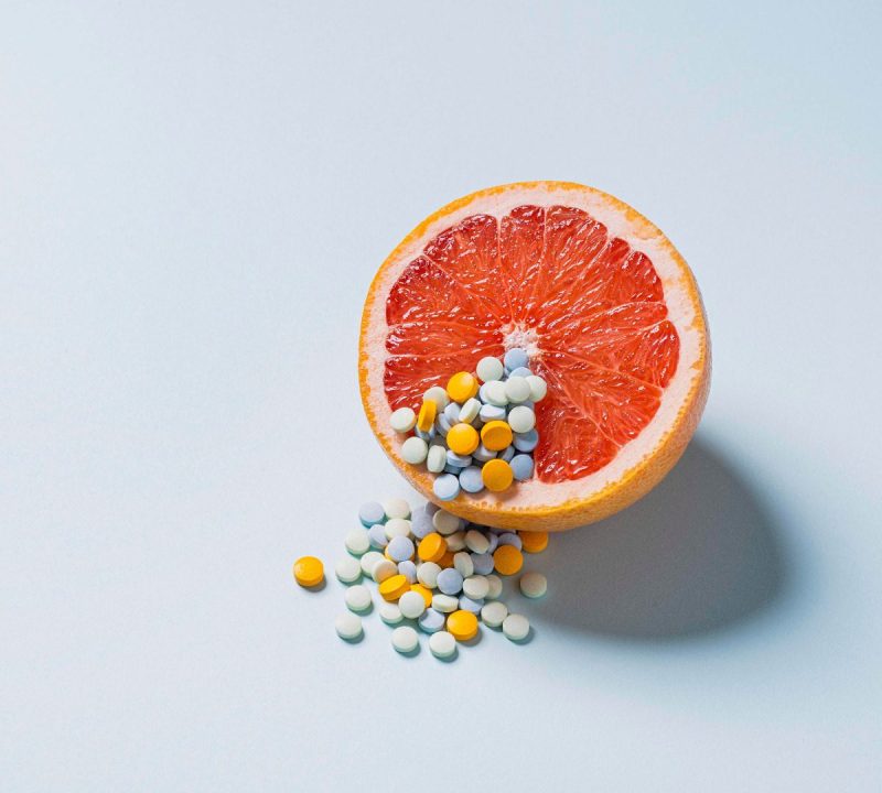 Colorful birth control pills on top of a grapefruit