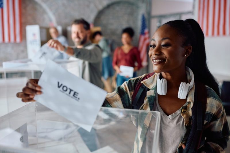 Photo of woman casting her ballot to vote