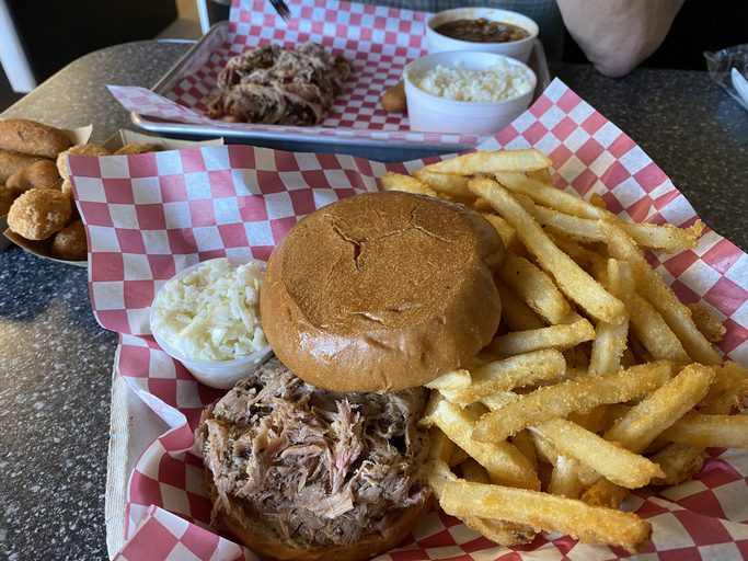 Vinegar based North Carolina Pulled Pork BBQ sandwich served with fries and slaw.