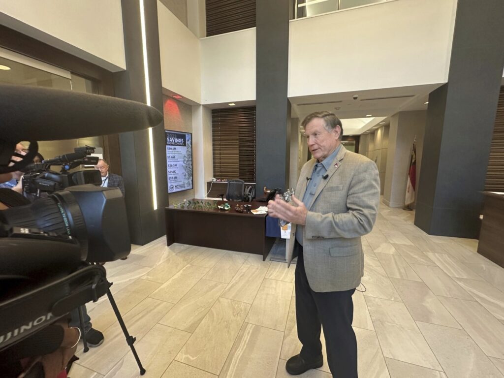 North Carolina Insurance Commissioner Mike Causey, right, speaks to the media before a hearing on homeowners' premium insurance rates in the state Department of Insurance building in Raleigh, N.C., on Monday, Oct. 7, 2024. (AP Photo/Gary D. Robertson)