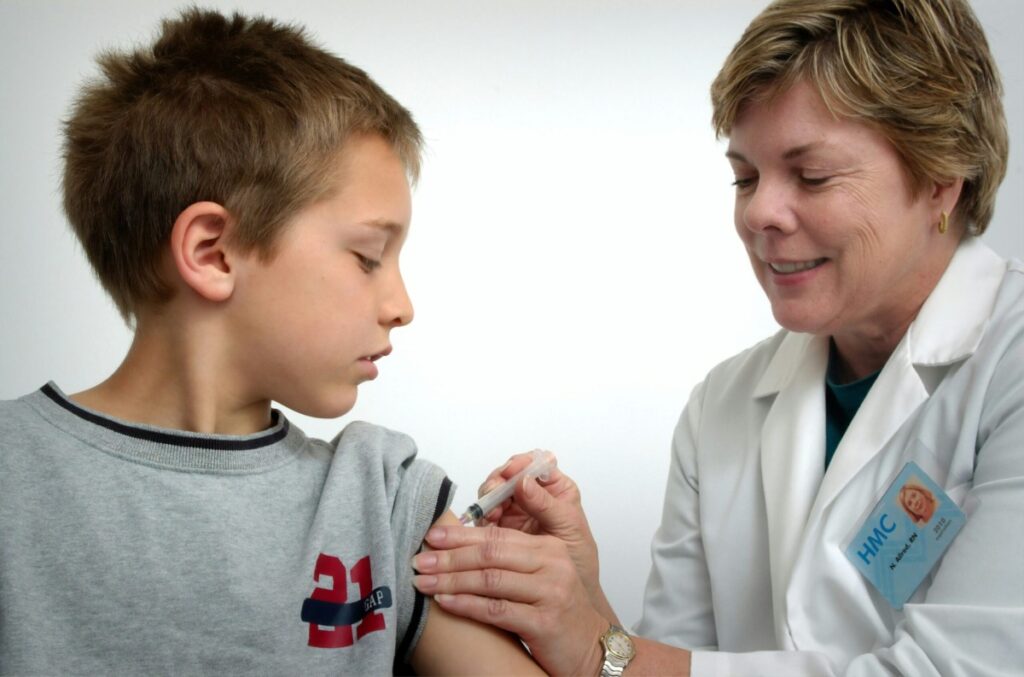 Young boy receiving a flu shot from a doctor.