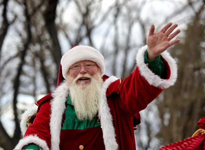 Santa Claus waving to the spectators at the Christmas parade.
