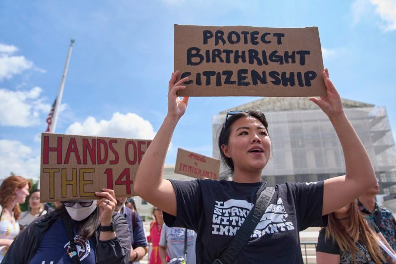 Photo of woman holding protest sign in front of US Supreme Court.