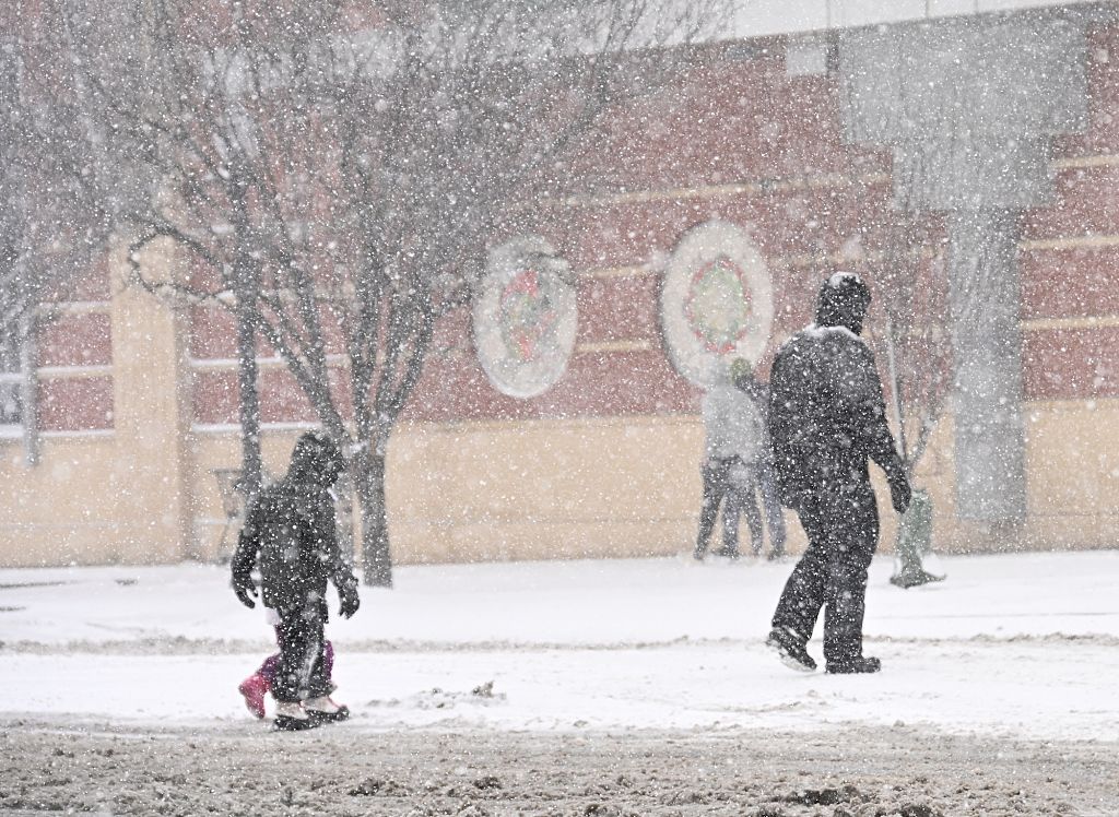 Photo of a father and his children walking in the snow
