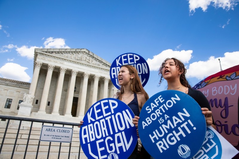 photo of two women holding pro-abortion signs outside the US Supreme Court building, in protest