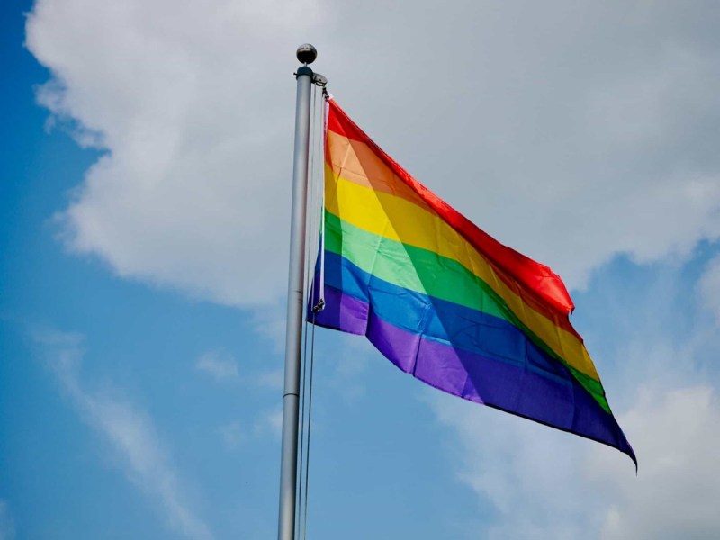 The Pride flag flying high in the sky.
